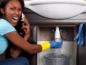Emergency plumbing repair for a leaking sink drain under a bathroom vanity in Palm Springs, CA
