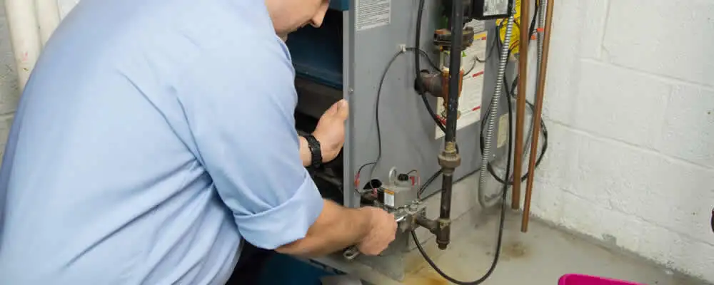 Furnace repair technician inspecting and servicing a home heating system in Palm Springs, CA
