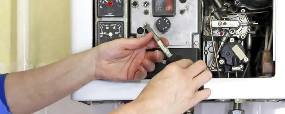 Heating repair technician adjusting boiler controls and components in Palm Springs, CA
