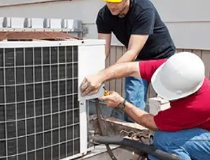 HVAC technicians repairing an outdoor AC unit on a rooftop in Palm Springs, CA