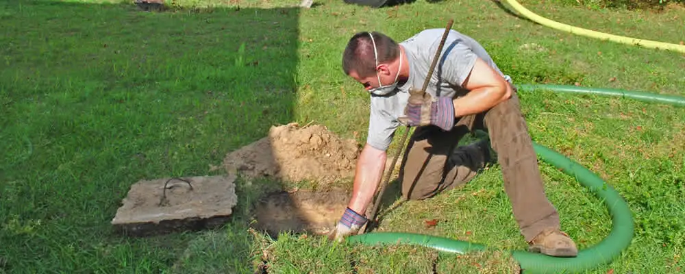Septic pumping technician servicing a residential septic tank in Palm Springs, CA