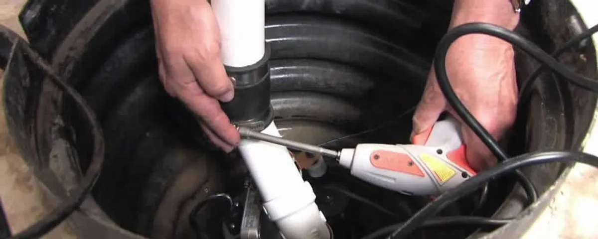 Sump pump installation technician connecting PVC discharge piping in Palm Springs, CA