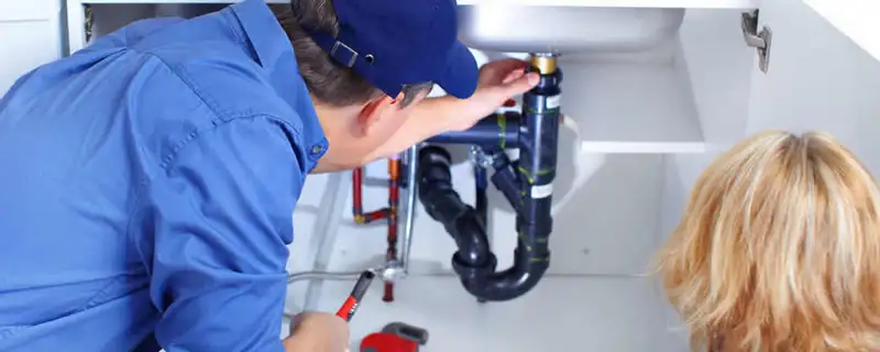 Plumber repairing under-sink drain pipes and fittings in Palm Springs, CA